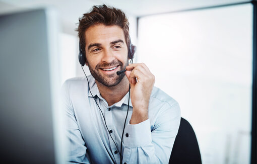 young, call centre agent, working in an office. guy on phone,
